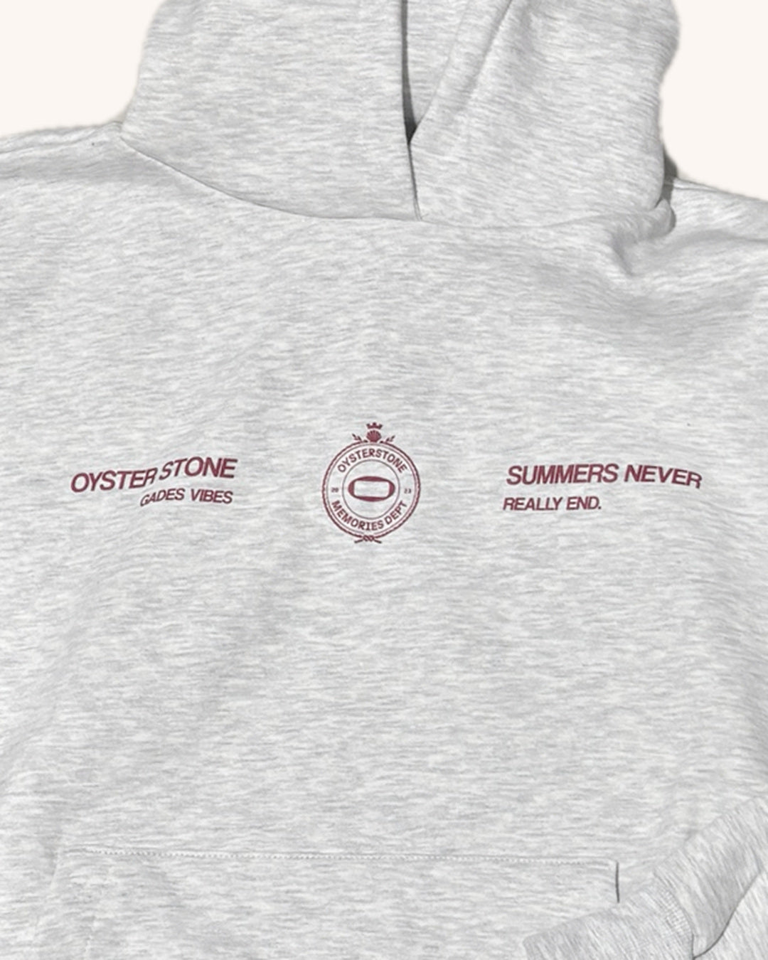 Detalle de la estampación granate en el pecho de la Hoodie MEMORIES gris: Oyster Stone Gades Vibes, escudo Memories Dept y Summers Never Really End