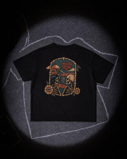 La camiseta negra extendida en el suelo bajo un foco, rodeada por un contorno de tiza